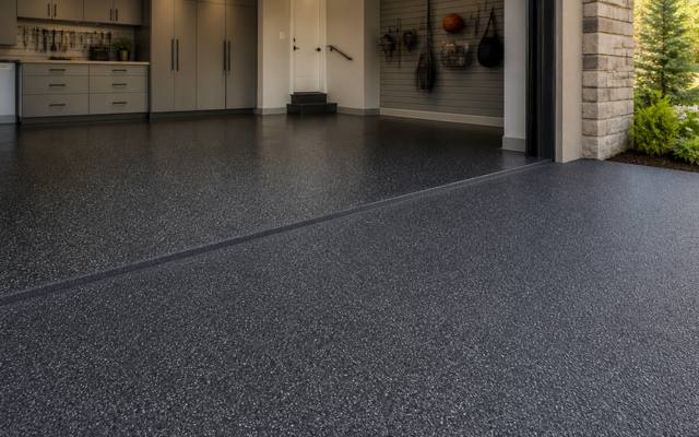 Two-car garage with a car parked on a finished charcoal rubber floor